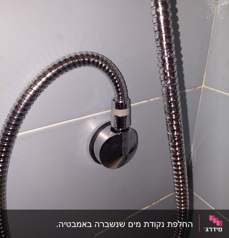 צינור מתכת מחובר לקיר בחדר אמבטיה